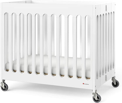 Foundations Boutique Folding Mini Baby Crib - Compact, Portable, Wooden Hotel Crib, Foldable Compact Cribs for Baby & Toddlers - Includes 3" Foam Mattress - White
